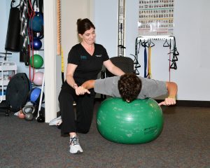 Lisa Weiss, PT, DPT, ATC guiding a young patient through balance therapy at Florida Spine Chiropractic, Vero Beach